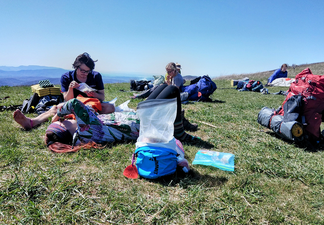 posttrail2 Backpacker reaches for his bear spray from the ULA Deploy Bear Canister Holder on his shoulder strap.