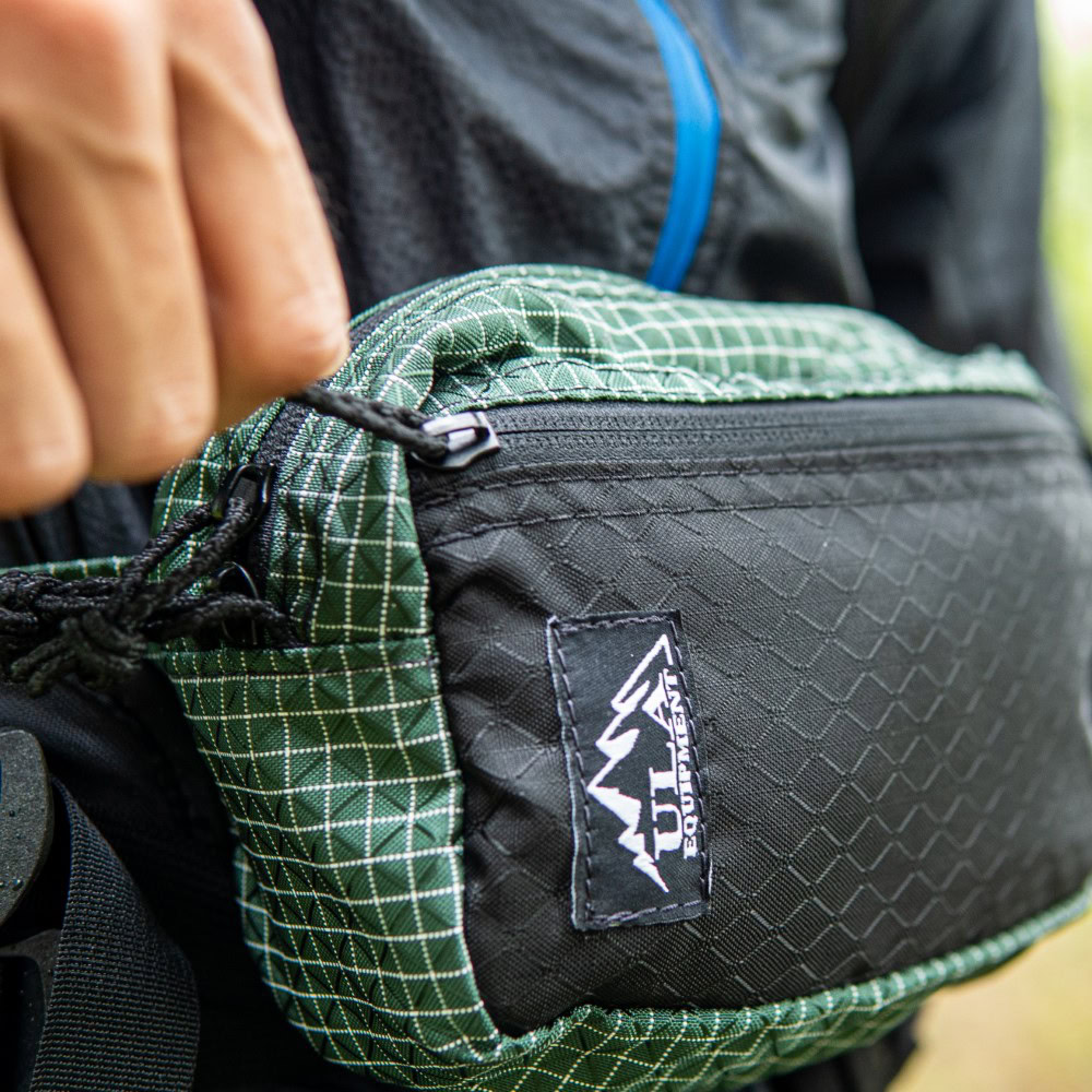 Backpacker zips front pocket of Spare Tire Fanny Pack