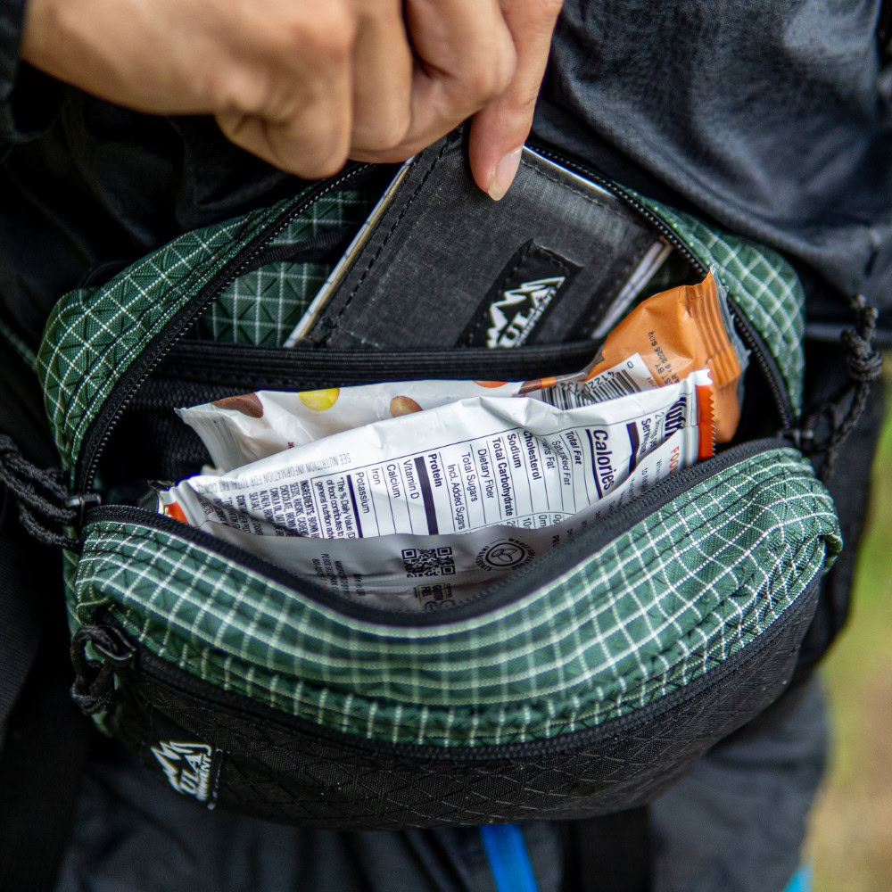 Backpacker removes wallet from spacious inner compartment of Green Robic Spare Tire Fanny Pack