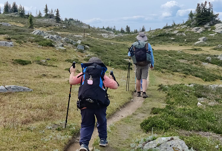 Backpacker sitting on a BearVault. The BearVault also makes an excellent chair. 