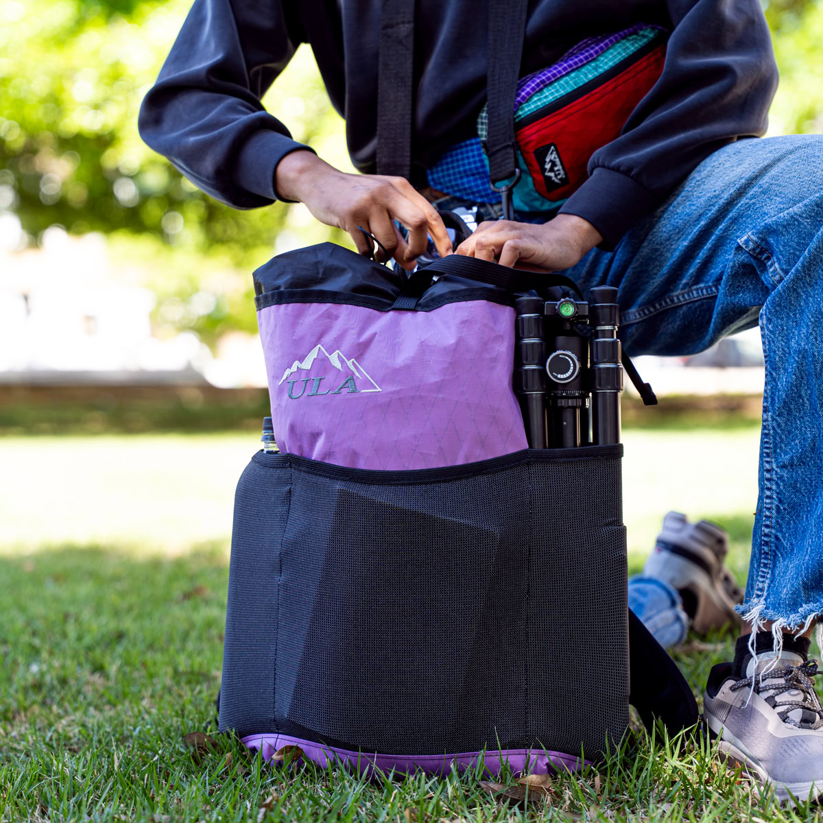 Hiker adjusts water-resistant ULTRA Spare Tire Waist Pack in Rain