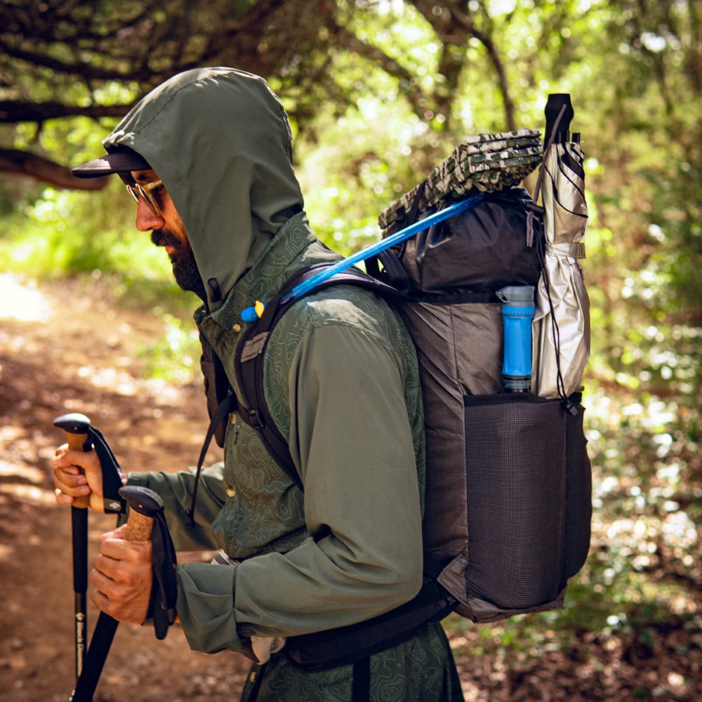 Backpacker puts a Bear Vault Bear Canister into a ULA CDT Backpack