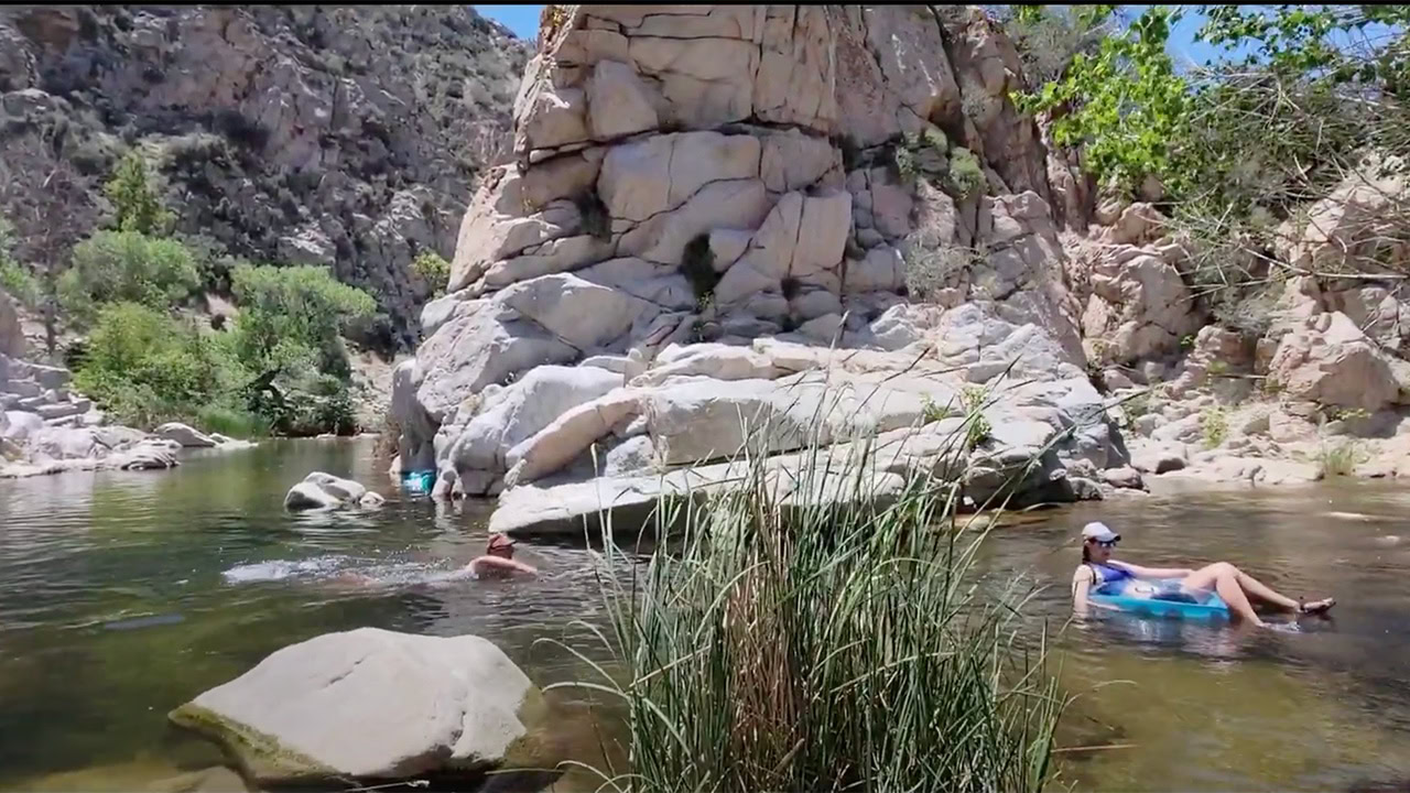 A man and woman swim in a hot spring