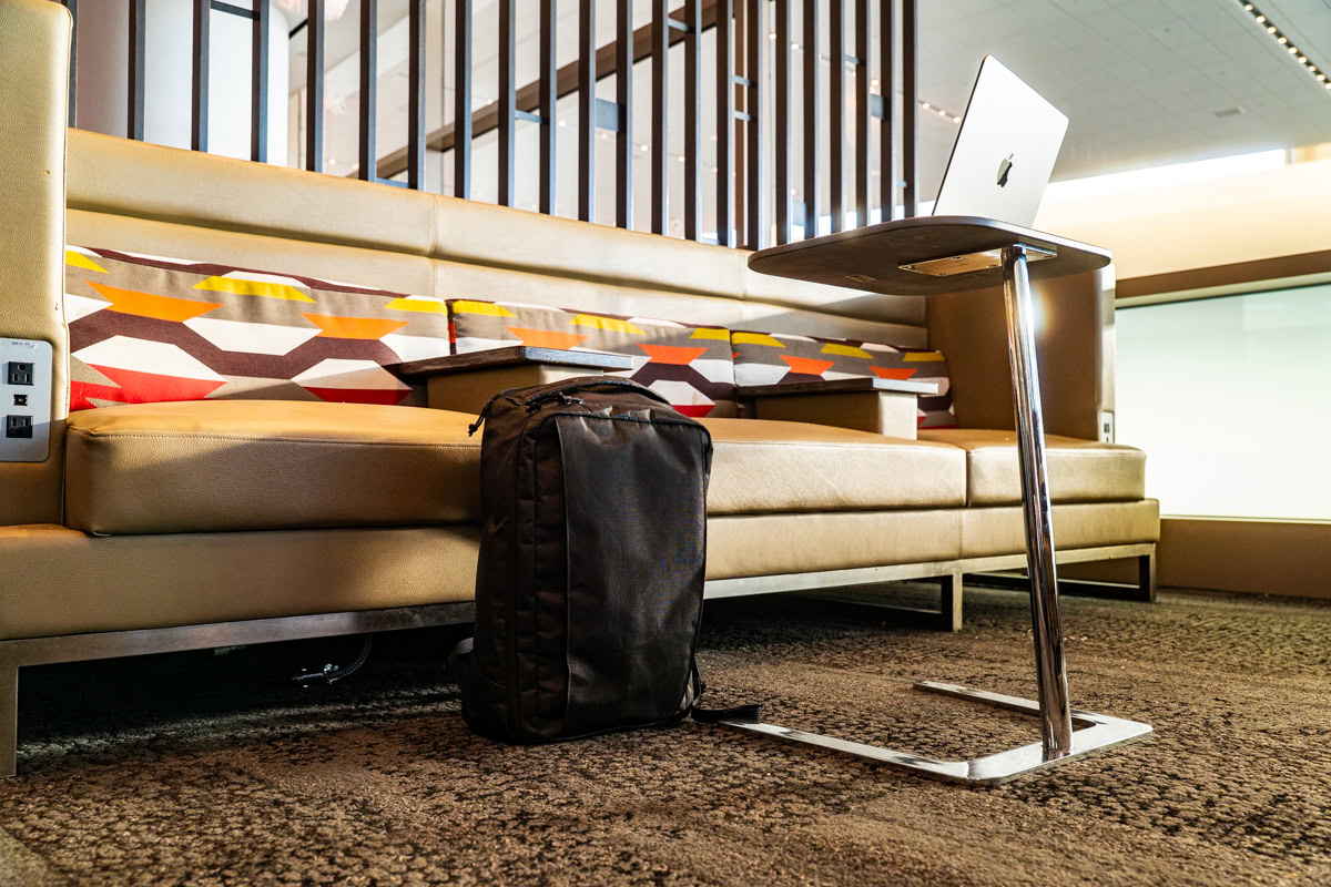 A ULA cicada backpack bext to a bench in an airport