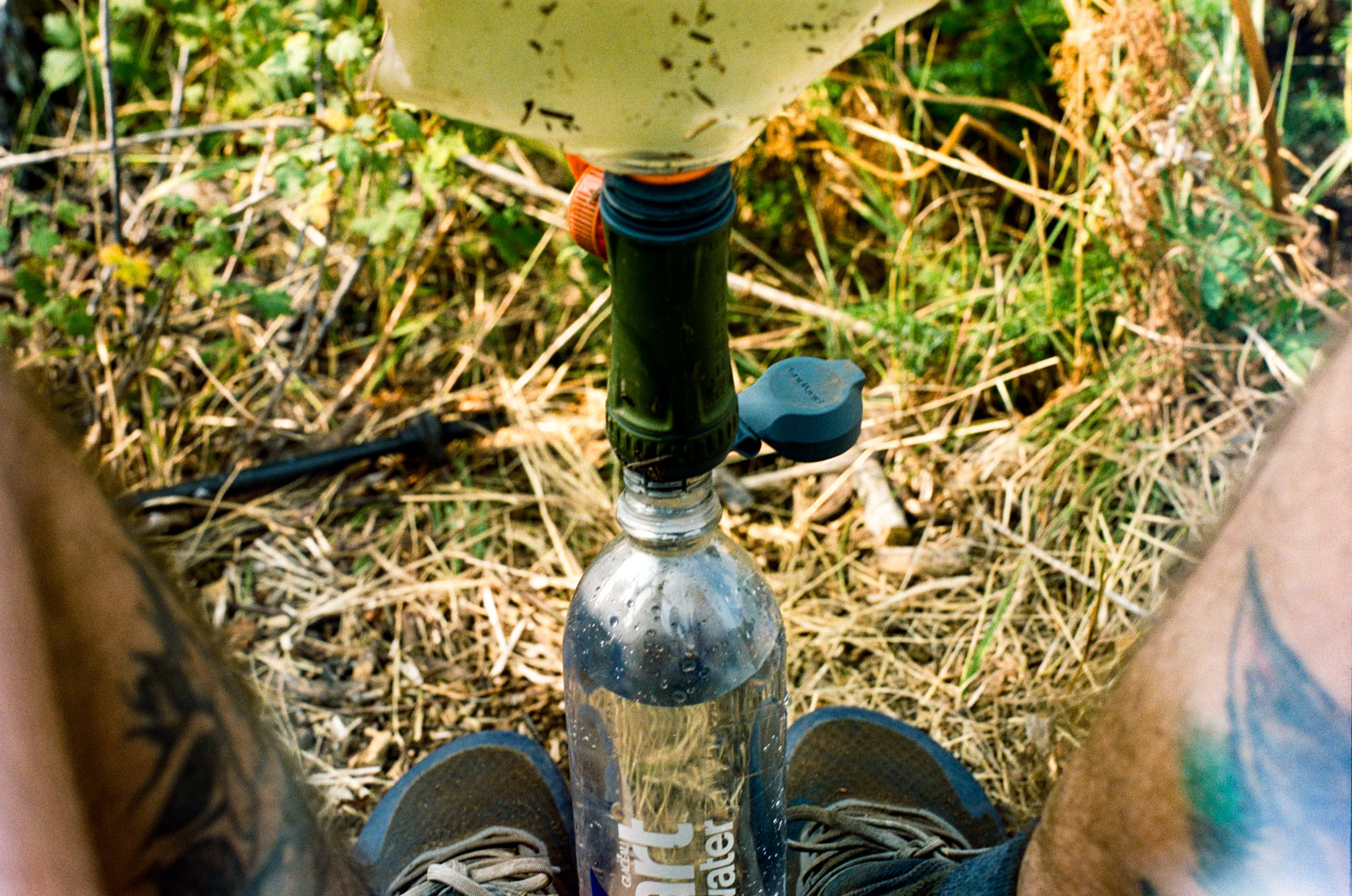 A man filter his water while on a backpacking trip.