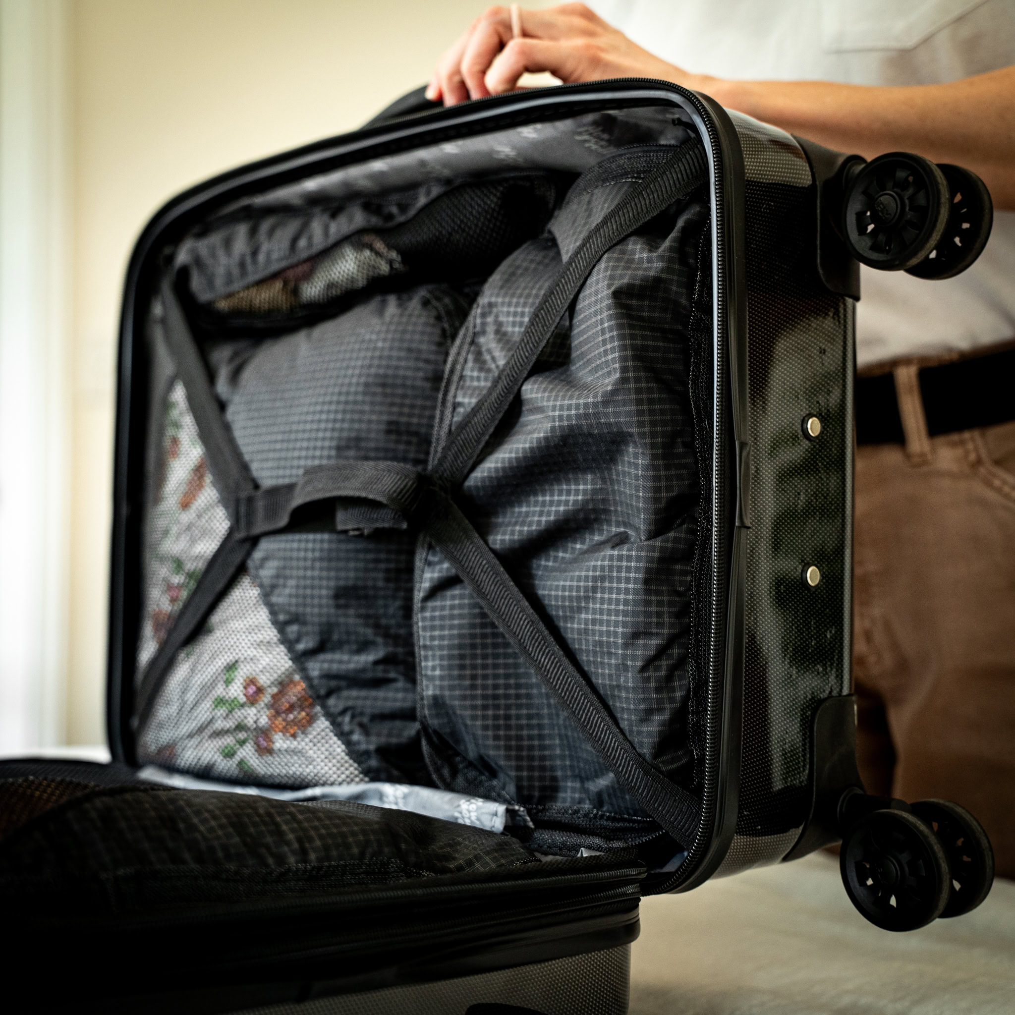 A traveler loads her carryon luggage bag