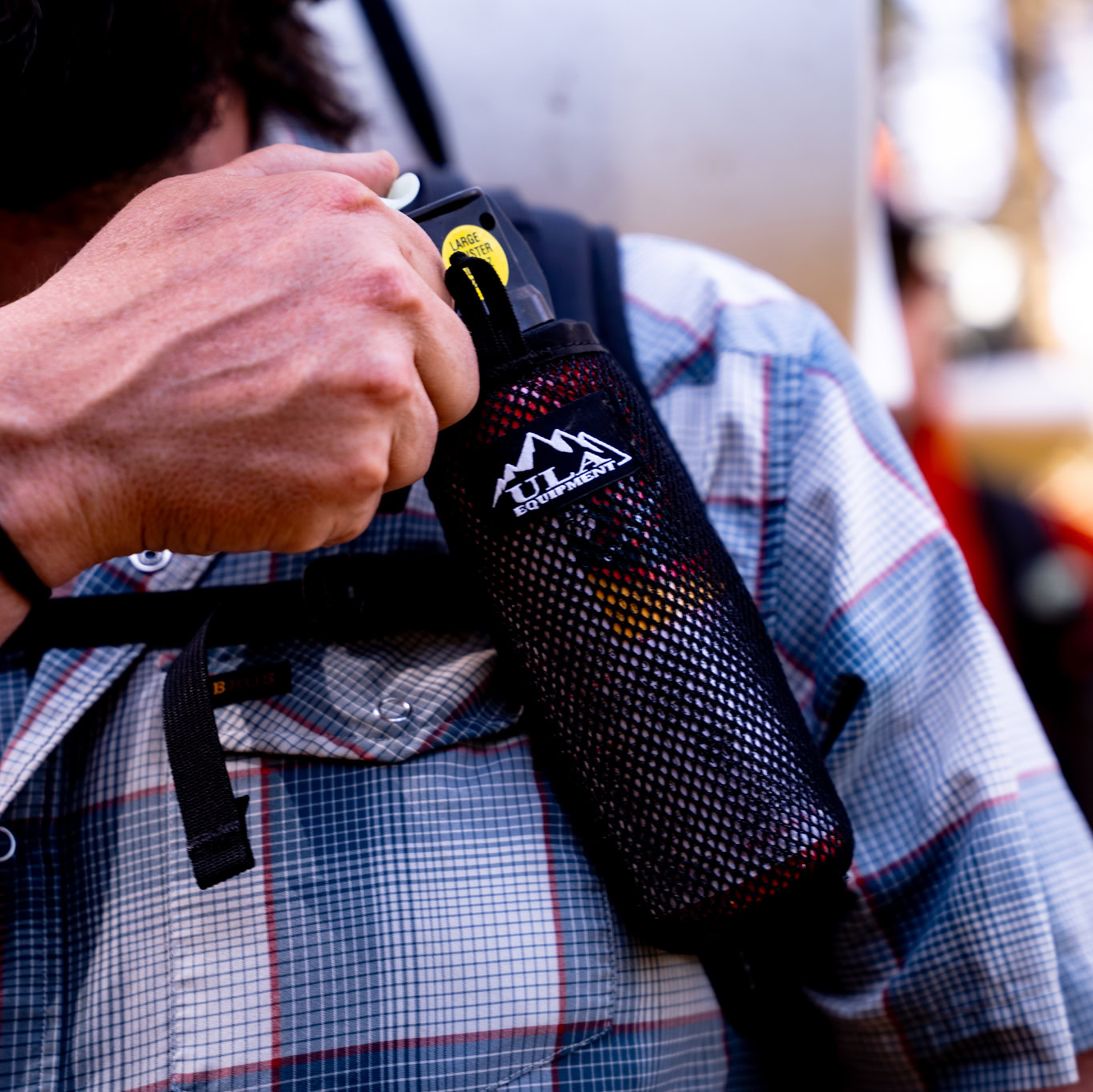 ULA Deploy on a shoulder strap. The wearer is preparing to remover the bear spray.